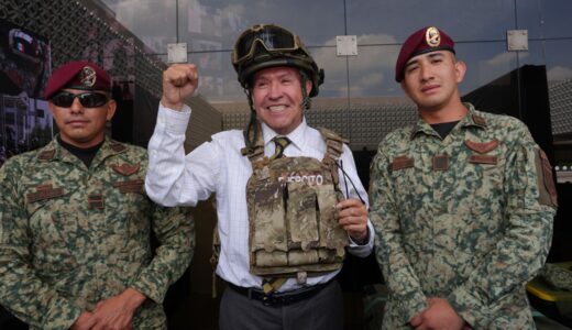 Ricardo Monreal porta chaleco y casco tácticos junto a dos militares durante una exhibición.